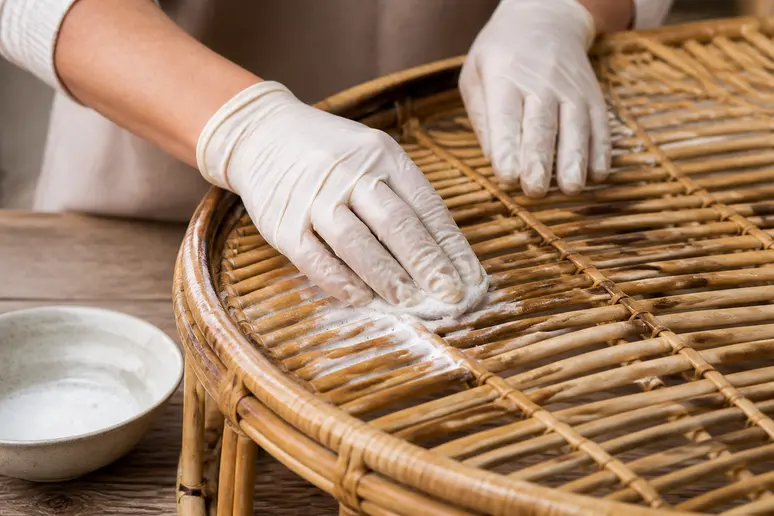 Application d'une pâte naturelle pour raviver l'éclat du rotin fatigué.