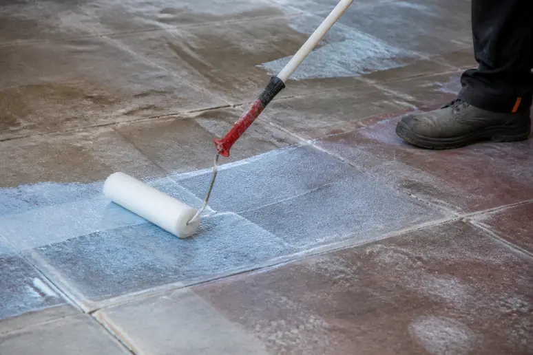 Application d'un primaire d'adhérence sur un ancien carrelage avant travaux