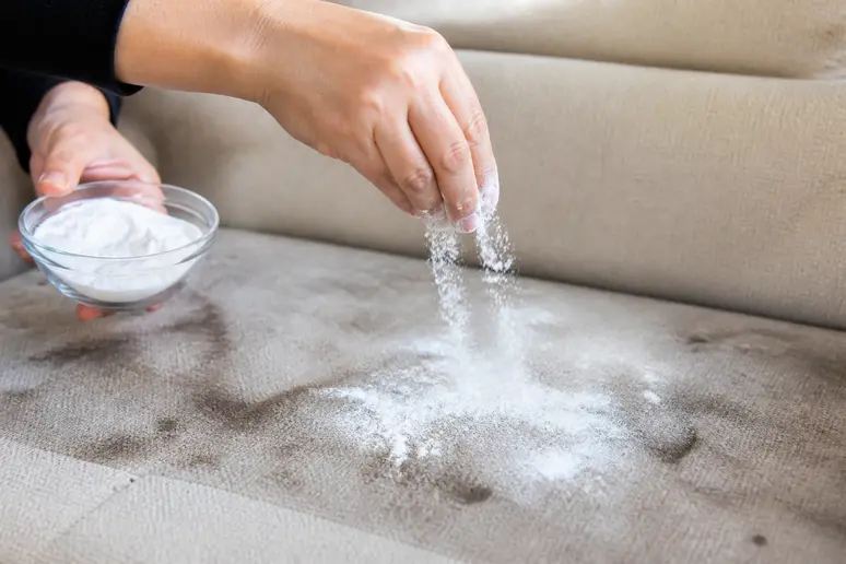 Application de bicarbonate de soude en poudre sur un textile très encrassé.