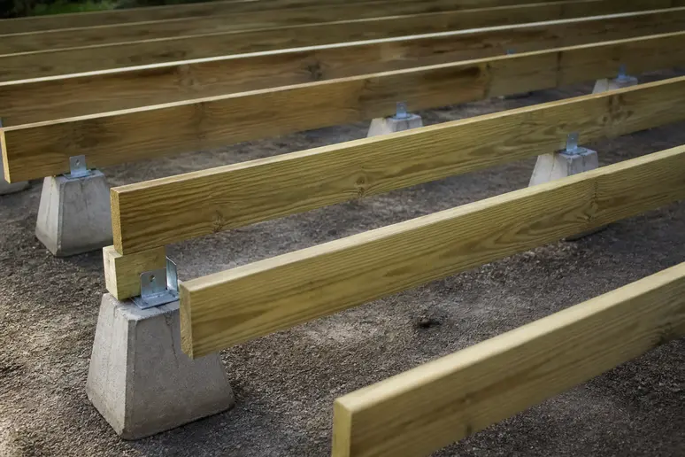 Espacement régulier des lambourdes sur plots pour la structure d'une terrasse en bois