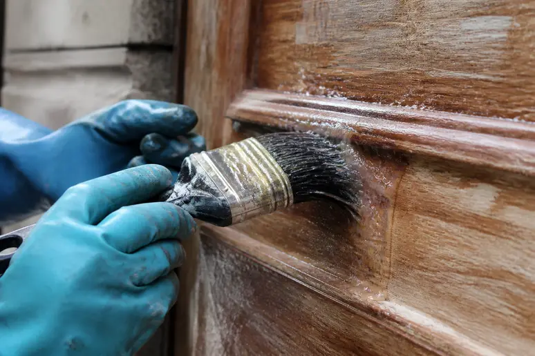 Application d'un gel décapant sur une porte en bois pour décaper la peinture sans poncer