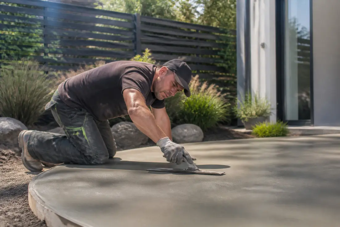 artisan lissant le sol pour estimer le prix béton terrasse de votre future cour extérieure