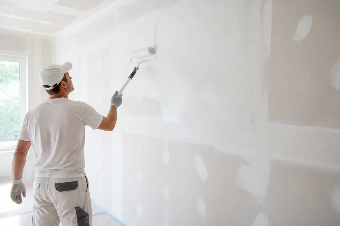 artisan appliquant une sous-couche blanche sur un mur en placo pour expliquer pourquoi sous-couche peinture